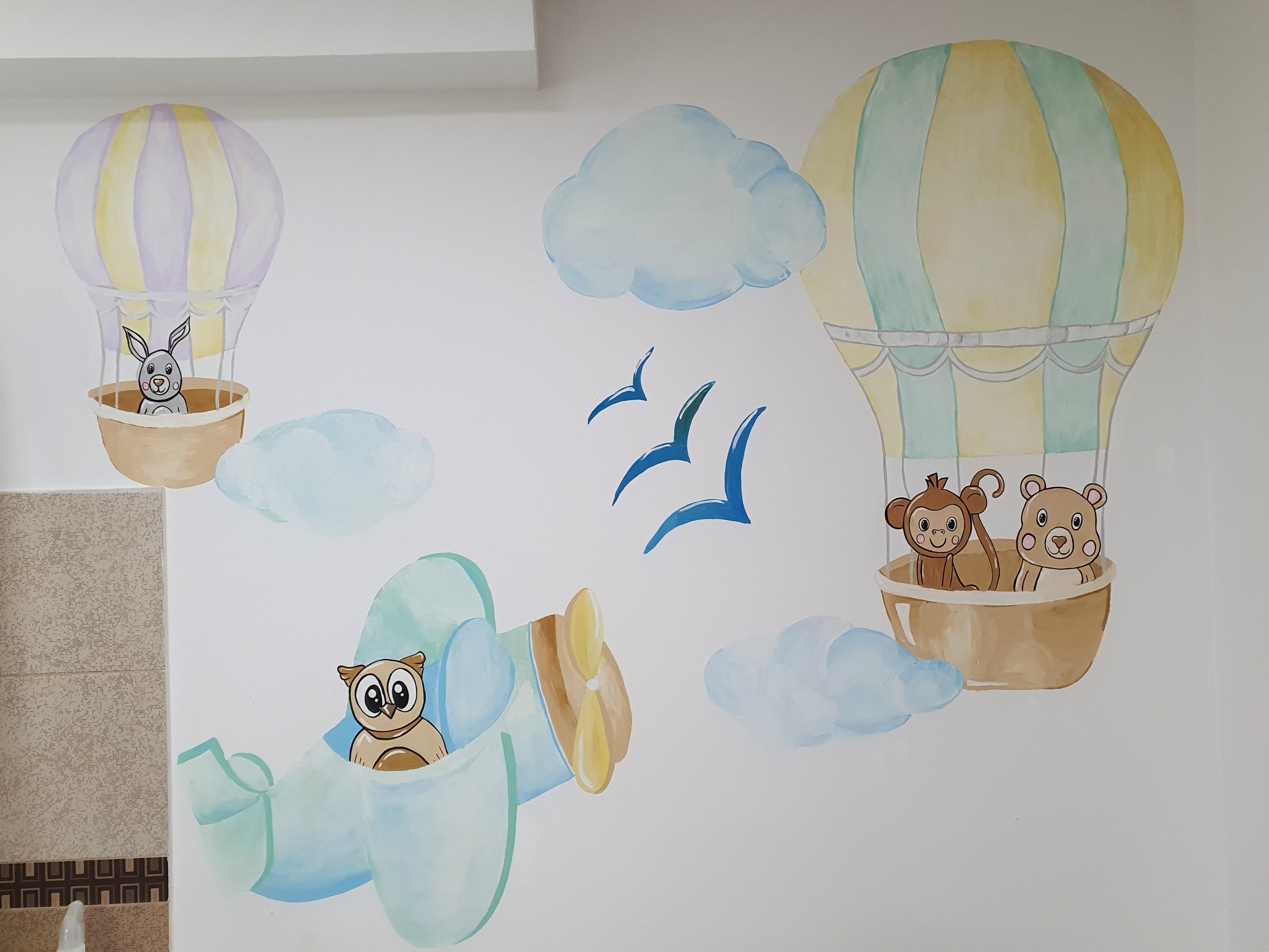 Pictură murală pentru cabinet stomatologic pediatric: balon cu aer cald și avion pictate cu culori pastelate. Lucrare realizată de ARTRA Paintings