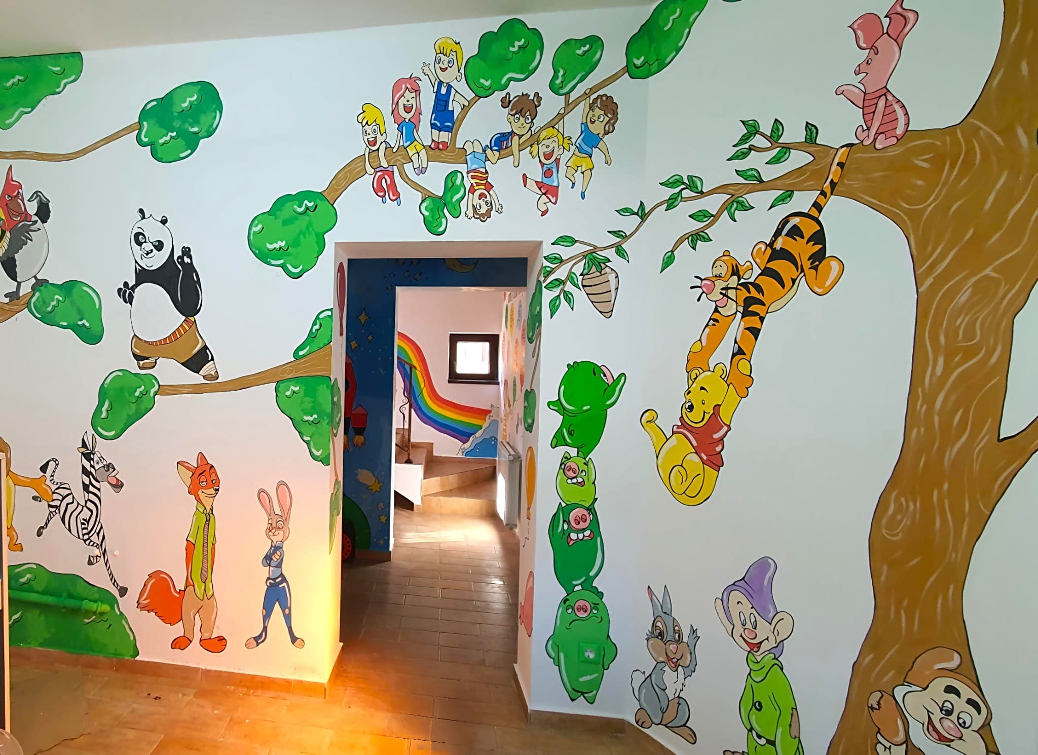 Pictură murală cu personaje pentru loc de joacă: scena de joacă cu personaje din desene animate pictate în receptie. Lucrare realizată de ARTRA Paintings